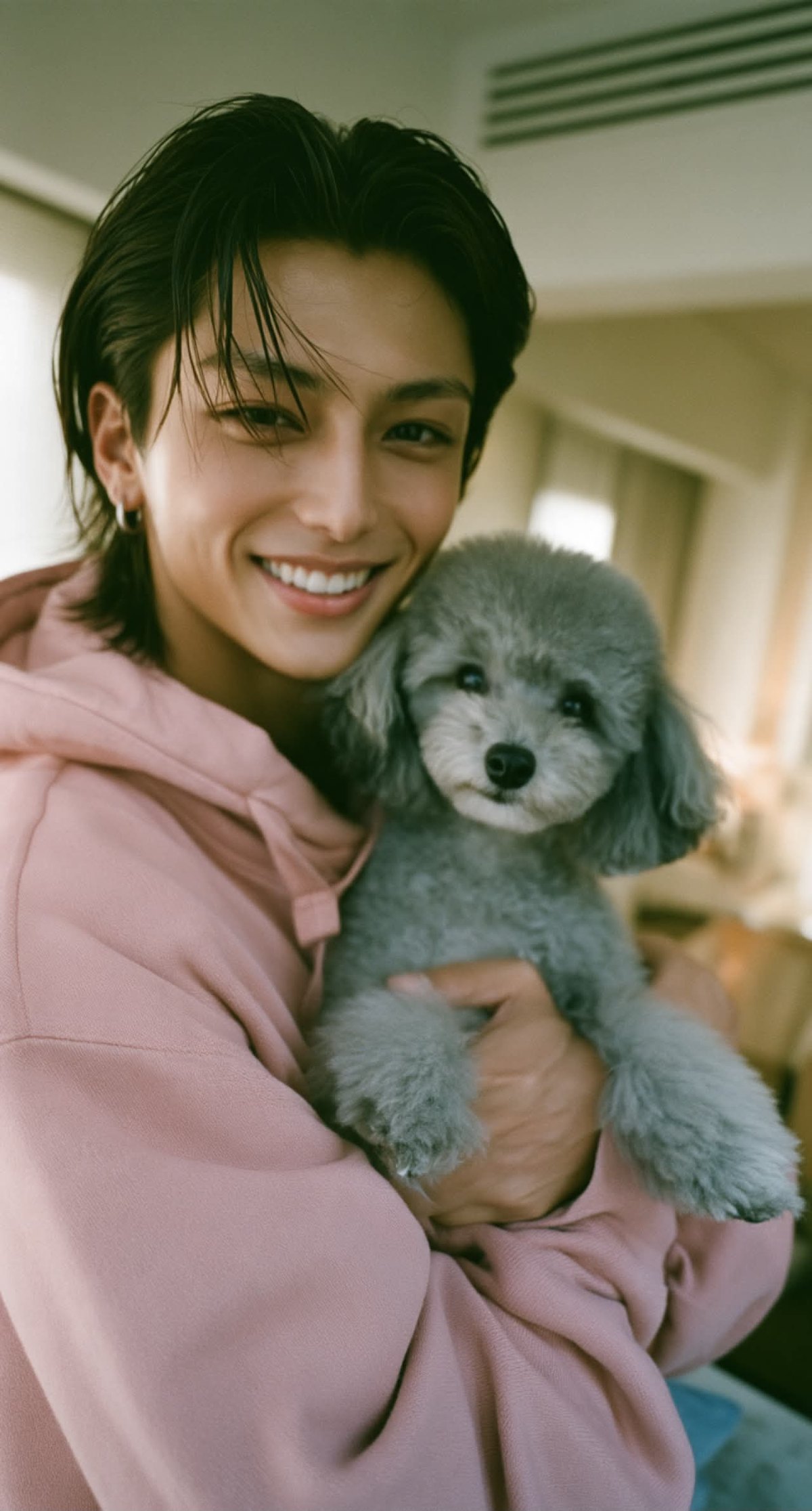 IORI smiling and holding LULU, a gray toy poodle